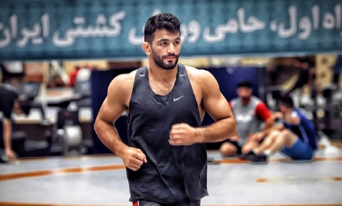 حسن یزدانی در حال تمرین کشتی با یک نوزاد