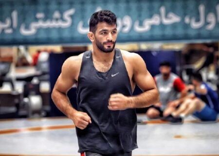 حسن یزدانی در حال تمرین کشتی با یک نوزاد